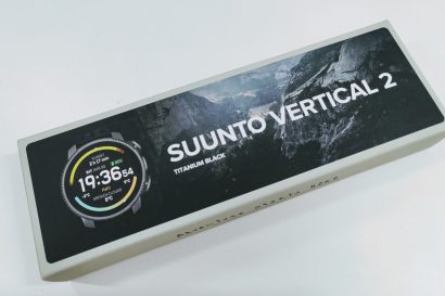 Boxed Suunto Vertical 2 Titanium Black smartwatch packaging shown at an angle with a partial image of the watch face on the left.