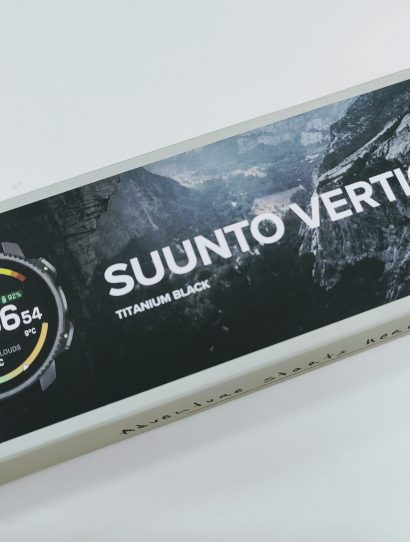 Boxed Suunto Vertical 2 Titanium Black smartwatch packaging shown at an angle with a partial image of the watch face on the left.