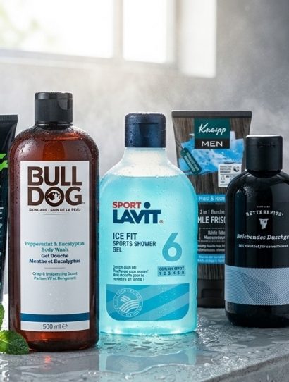 Assorted men’s grooming products lined up on a wet bathroom counter, including Bull-Dull body wash and Lavit ice-fit shower gel.