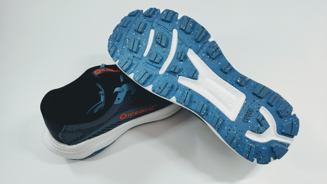 Blue Icebug running shoe with a rugged blue outsole and white midsole, shown from underneath to highlight tread pattern.