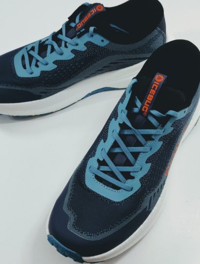 Pair of blue athletic running shoes with light blue laces on a white surface, arranged diagonally.