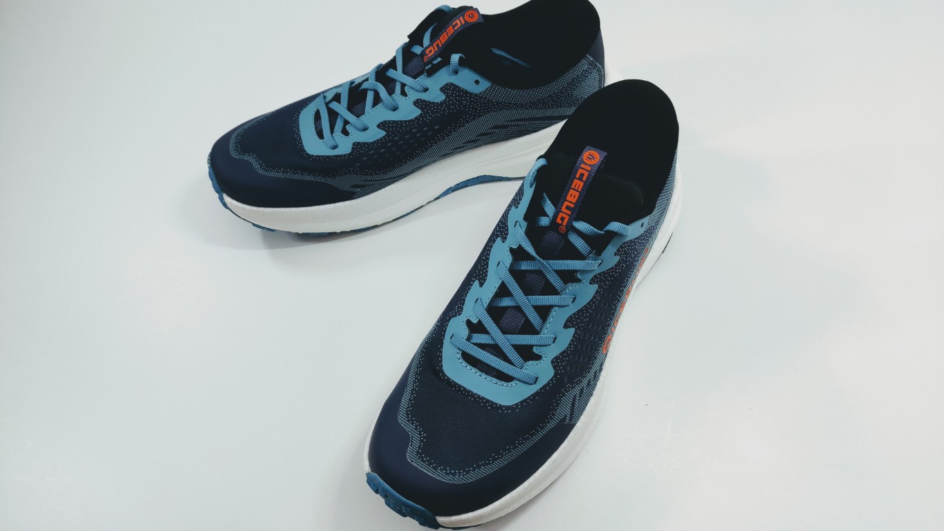 Pair of blue athletic running shoes with light blue laces on a white surface, arranged diagonally.
