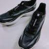 Pair of black and gray running shoes with white soles on a white surface.