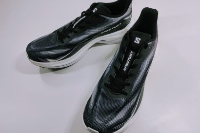 Pair of black and gray running shoes with white soles on a white surface.