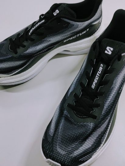 Pair of black and gray running shoes with white soles on a white surface.