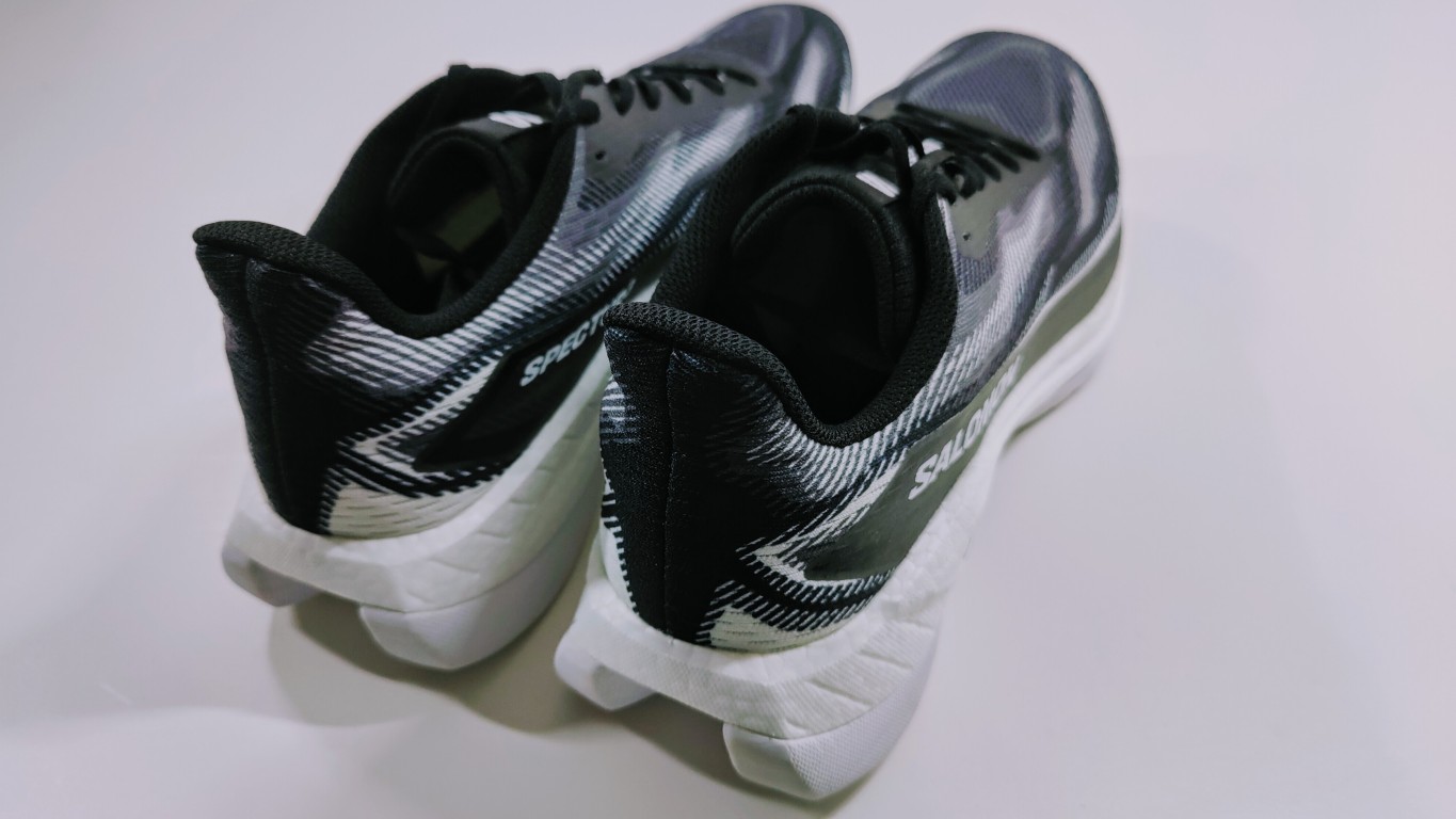 Pair of black and gray running shoes with white soles on a white surface.