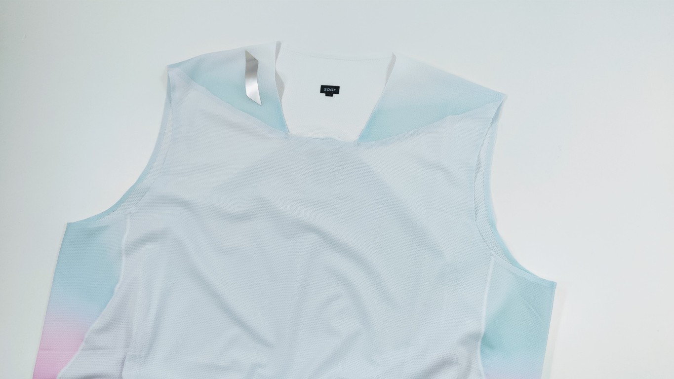 Light blue sleeveless athletic top with a white front panel and pastel pink-to-blue gradient on the sides, made of mesh fabric.