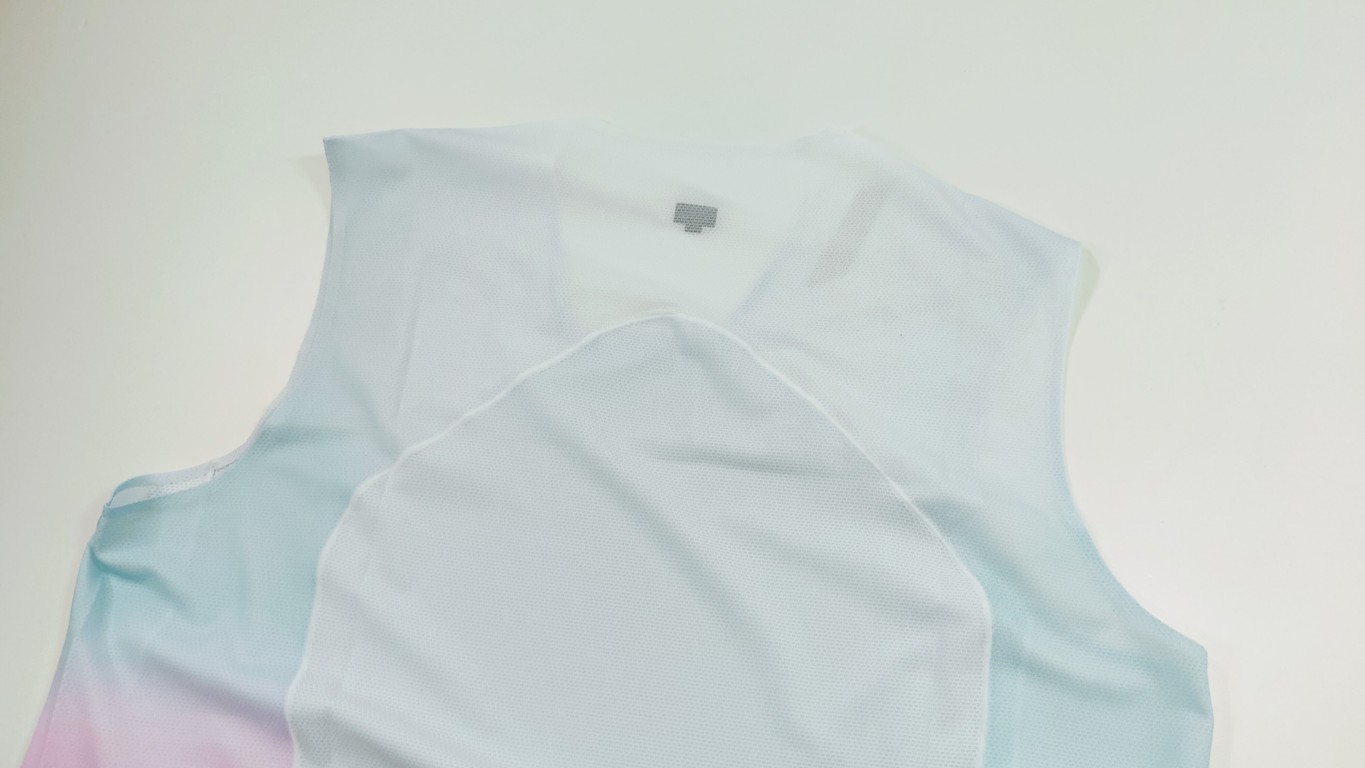 Light blue sleeveless athletic jersey with a white panel laid on a white surface.