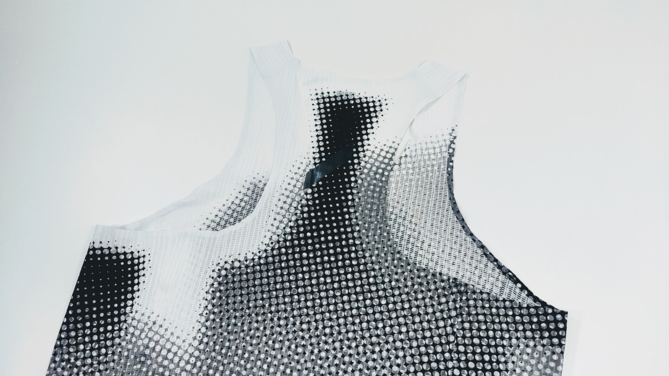 White sleeveless top with a dense black-to-gray dot gradient, photographed on a light background.