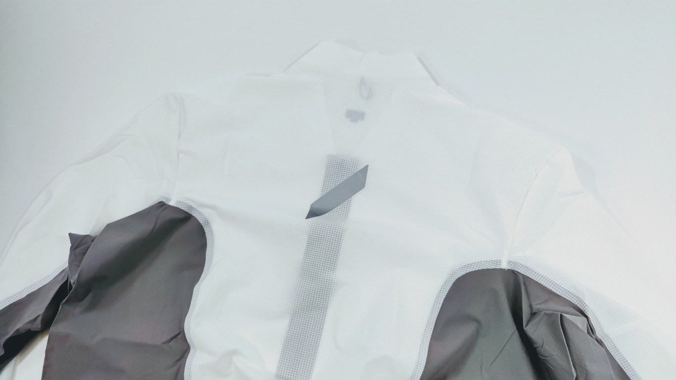 White and gray jacket laid flat, showing back with light-gray shoulders and sleeves on a white surface.