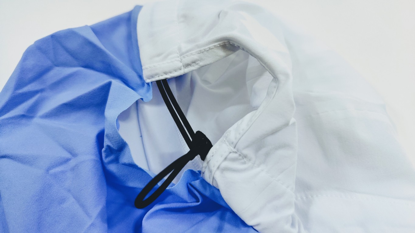 Close-up of a two-tone jacket hood in white and blue with a black drawstring toggle.