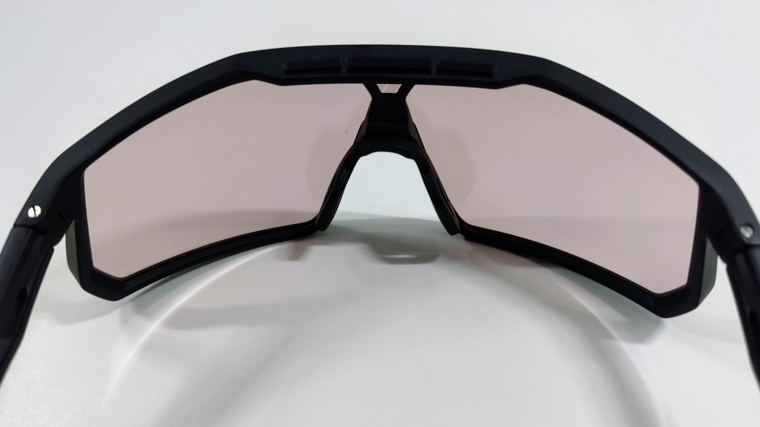 Inside view of black sports sunglasses showing the single shield lens, adjustable nose pads and vents in the upper frame