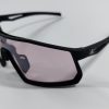 Black sports sunglasses with light violet shield lens seen from an angle on a white surface