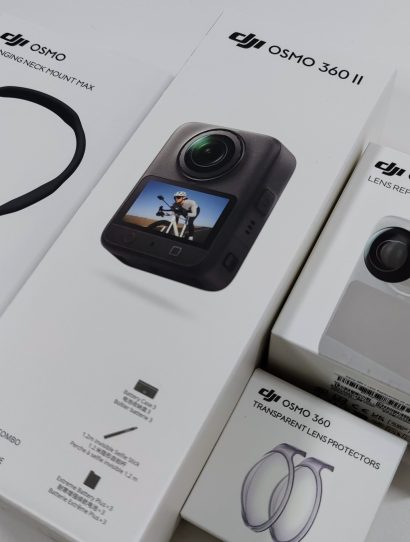 Stack of boxes: Hanging Neck Mount Max, Osmo 360 II, Lens Replacement Kit and Transparent Lens Protectors.